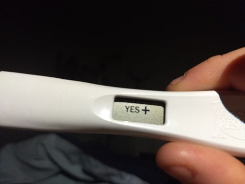 An expecting Mosie Parent holds up a positive pregnancy test.