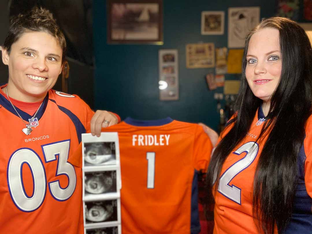 Two women share birth announcement in matching Chicago Bears jerseys with baby jersey and sonogram images.