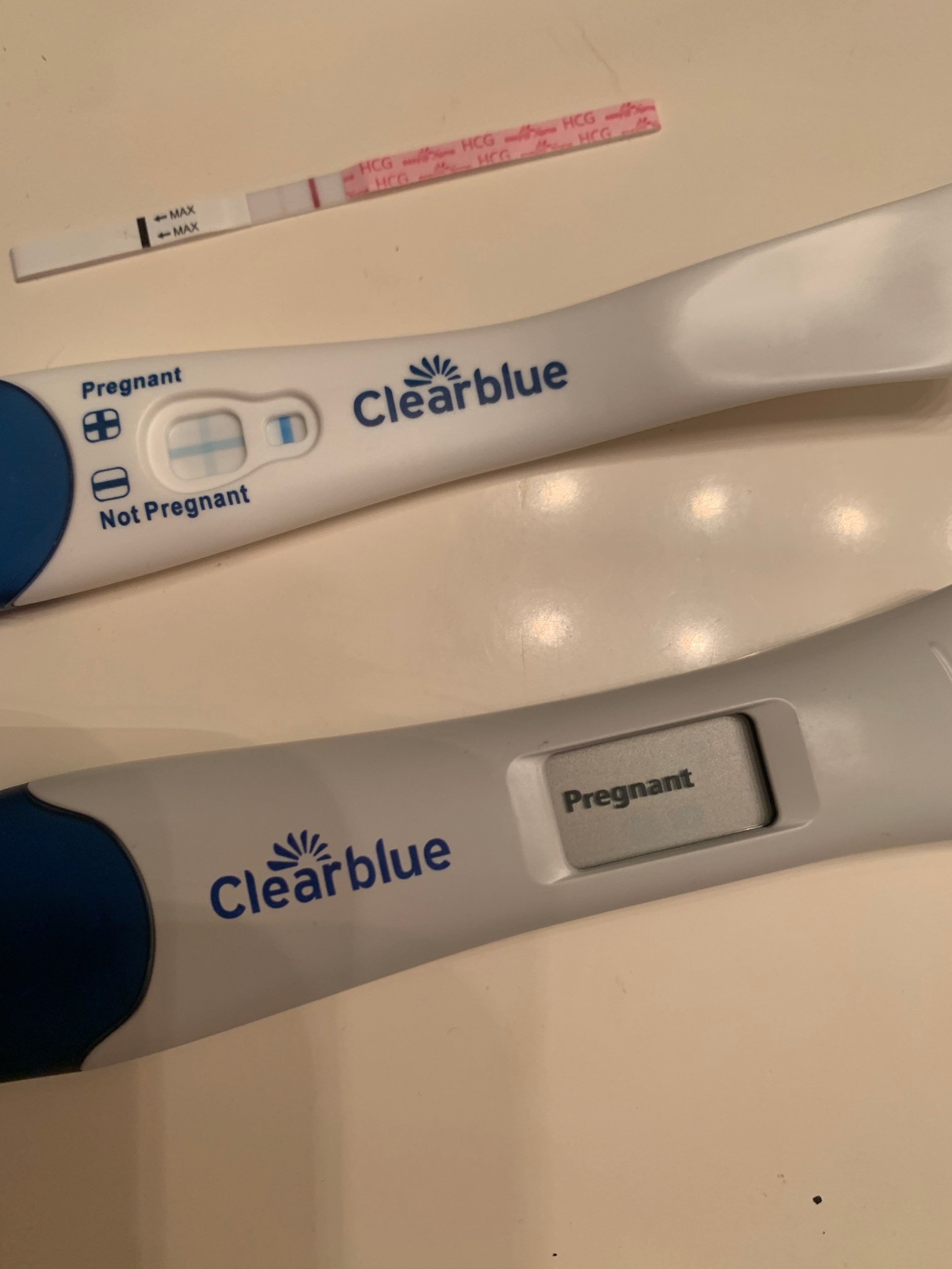A positive digital, regular, and strip pregnancy test from a Mosie family