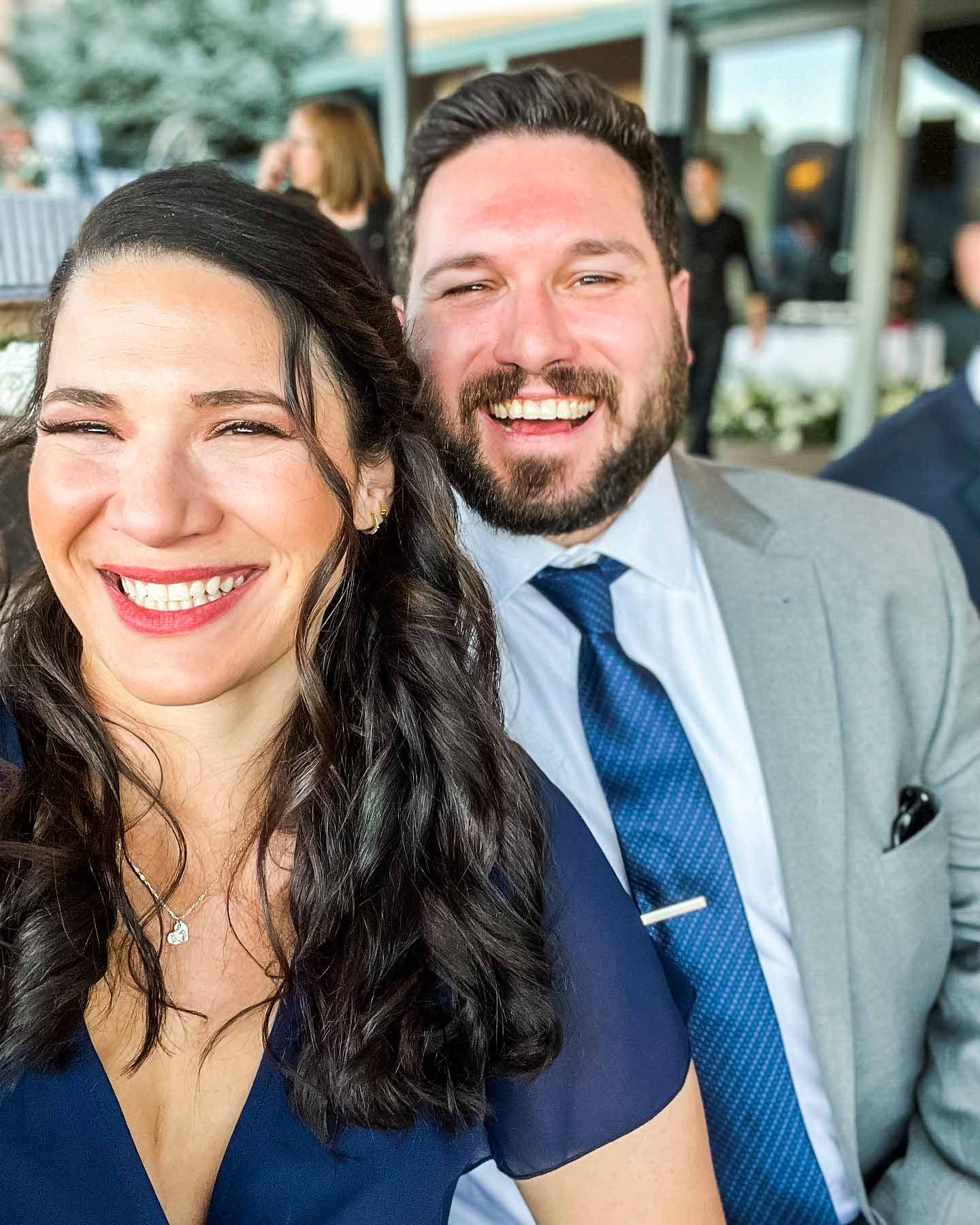 Husband and Wife smile in formal clothing at Wedding