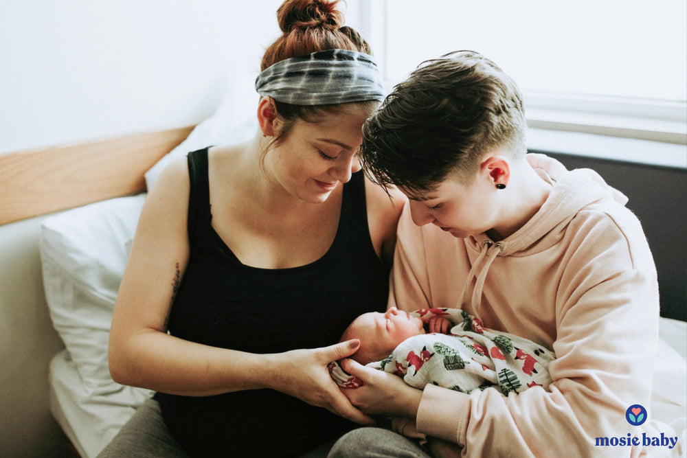 newborn mosie baby held by her two lesbian moms