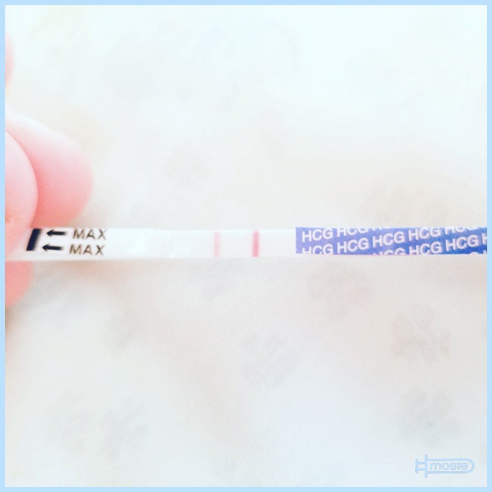 positive pregnancy test held by a mosie user