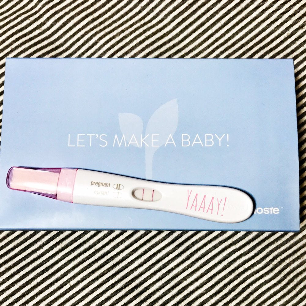 a positive pregnancy test on top of a mosie baby box
