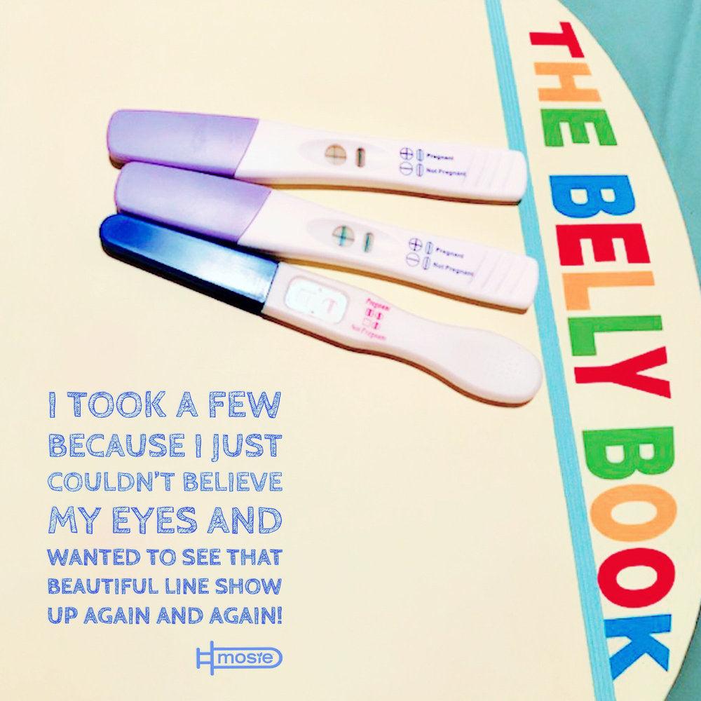 three positive pregnancy tests on top of "The Belly Book" from a Mosie user 