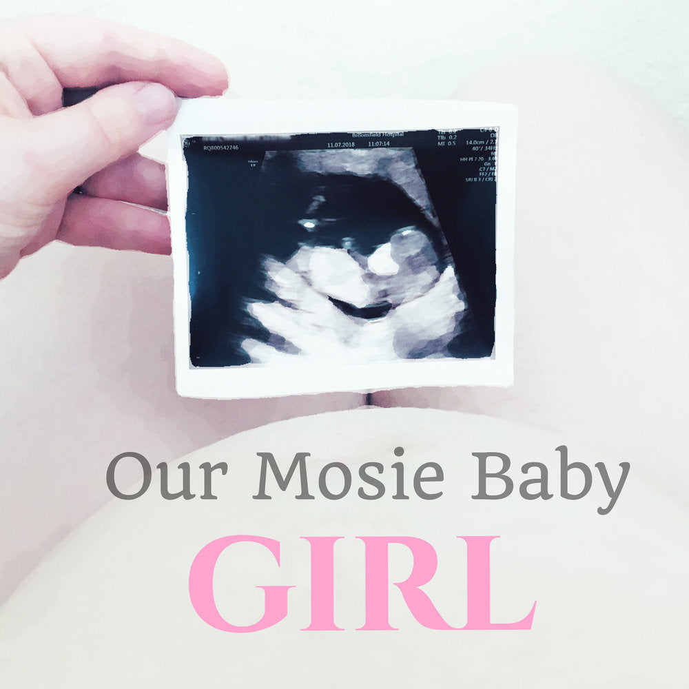 Person holding sonogram image with text reading "our Mosie baby girl"
