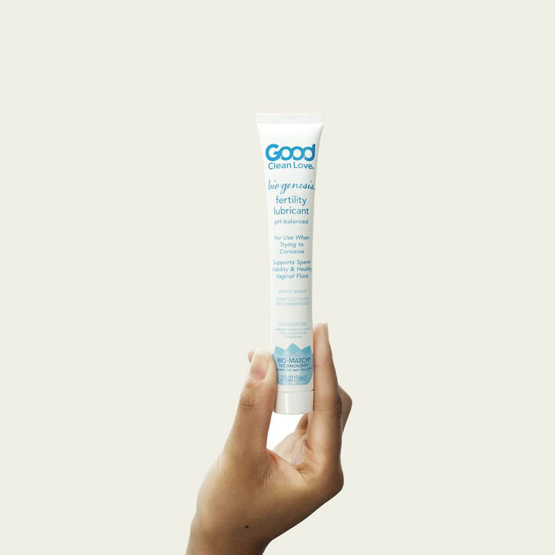 A hand holding a bottle of A bottle of Biogenesis Good Clean Love Fertility Lubricant up against a white background